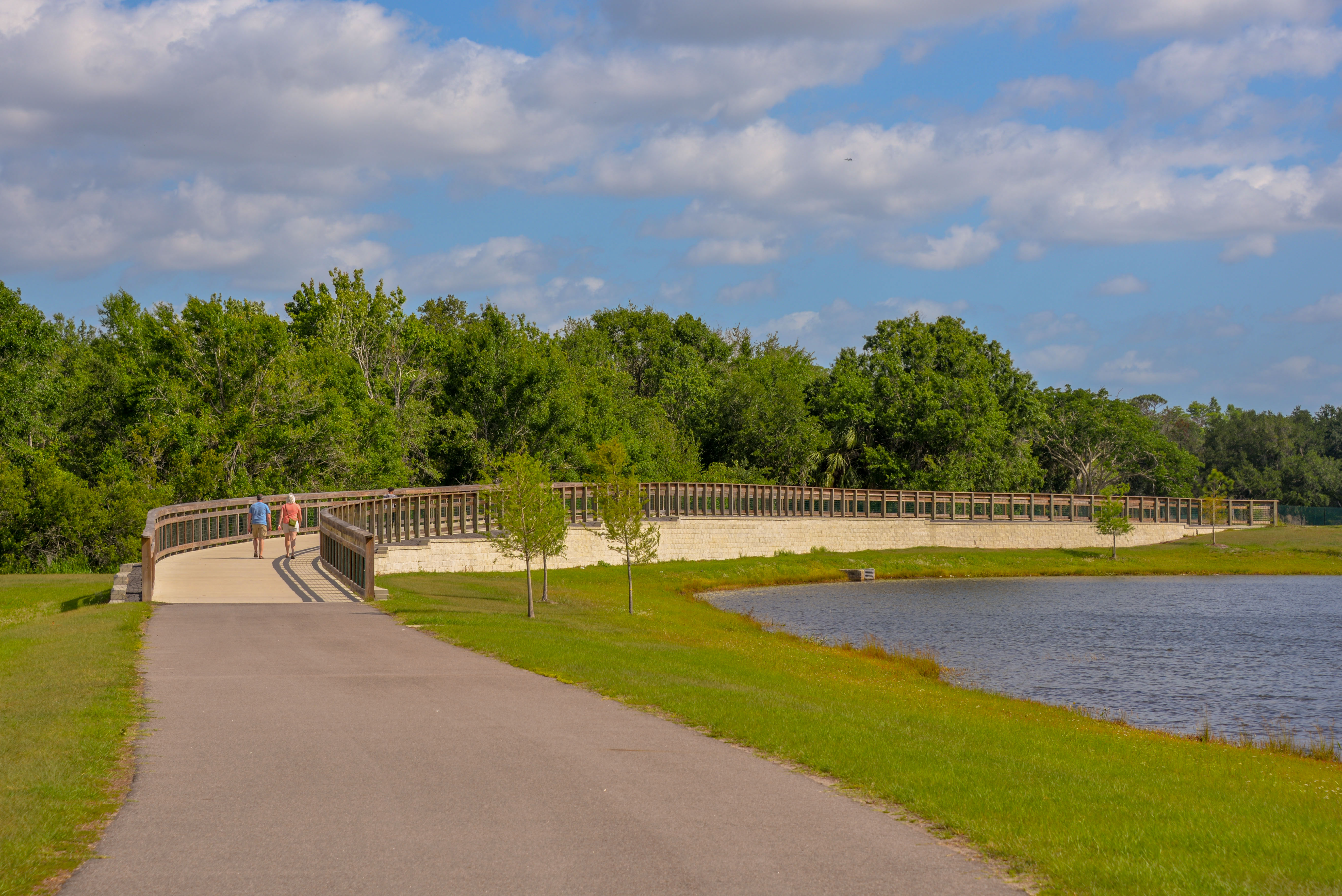 This is a photo of two people walking on Shingle Creek Regional Trail in the City of Kissimmee