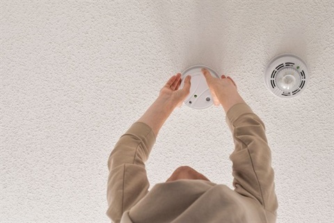 Photo of person changing a smoke alarm